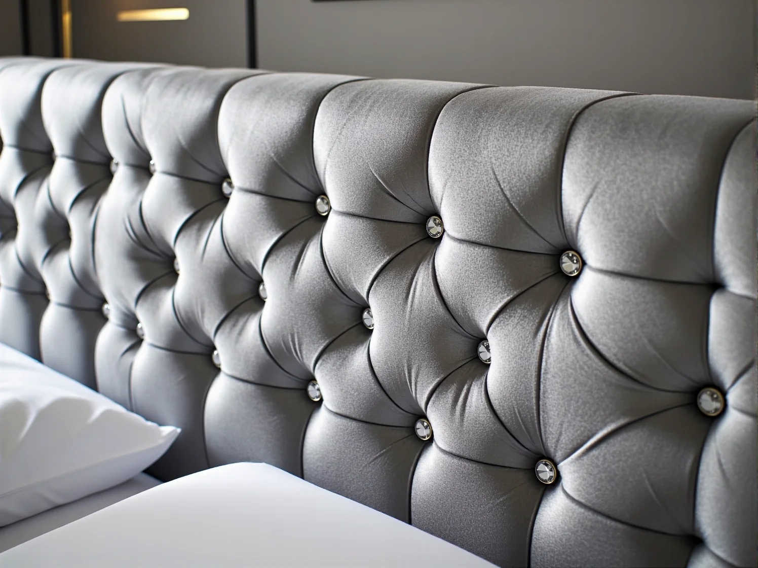 Elegancka sypialnia glamour z szarym łóżkiem modułowym i stylowymi dodatkami.